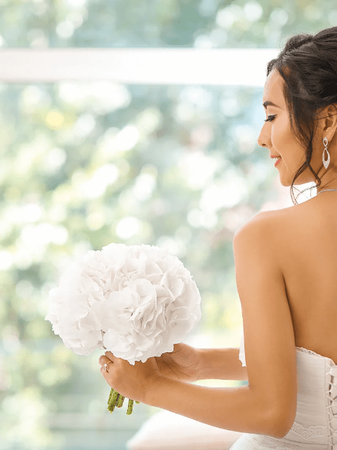 Back View of a Filipina Bride Looking at Her Bouquet of White Roses