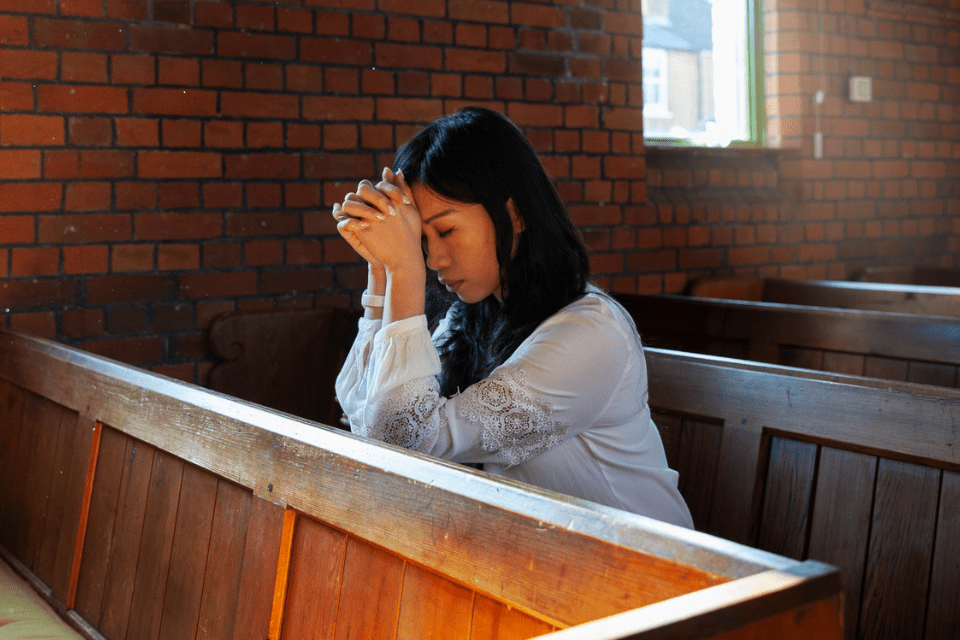 Woman from the Philippines Praying in Church - What Makes a Filipina Attractive - Blossoms Dating Blog