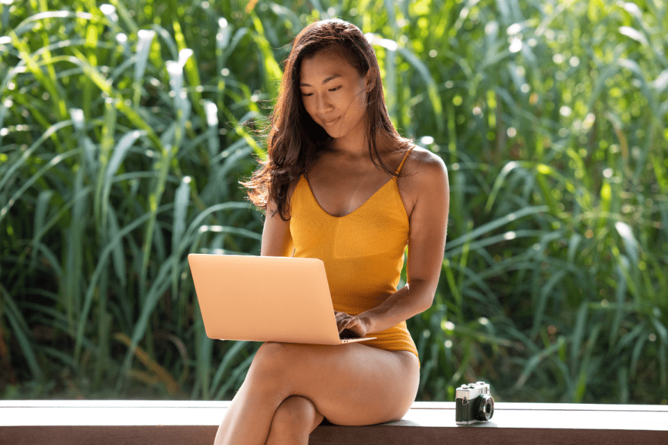 Pretty Filipina Woman on Vacation Working on Her Laptop - What Makes a Filipina Attractive - Blossoms Dating Blog