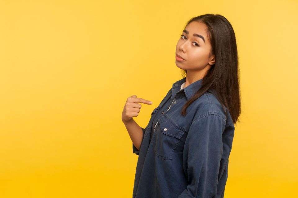 Filipino Single Woman Pointing to Herself - What if You’re a Filipina Being Accused Falsely of Scamming - How to Spot a Filipina Scammer - Blossoms Dating Blog