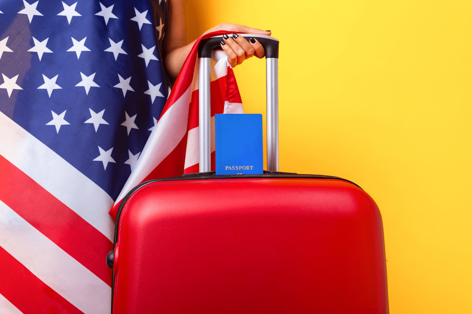 American Flag with Passport and a Red Suitcase  - How Much Is a Fiancée Visa for a Filipina - Blossoms Dating Blog