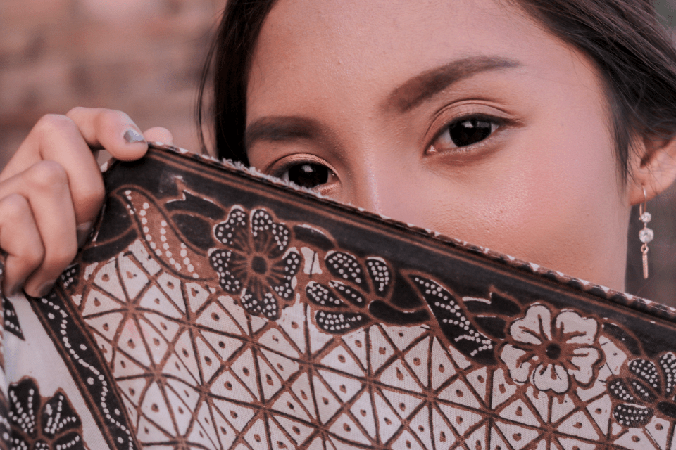 Filipina Hiding Behind a Batik Scarf While Lying