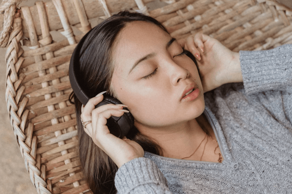 Filipina Woman on Hammock Listening to Music on Her Headphones