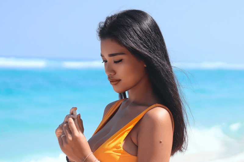 Slim Filipina Collecting Seashells at the Beach