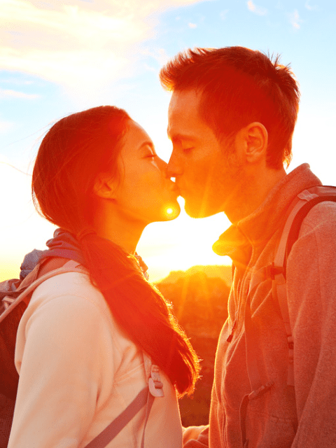 Romantic Lovers Kissing at Sunset While Hiking on a Date