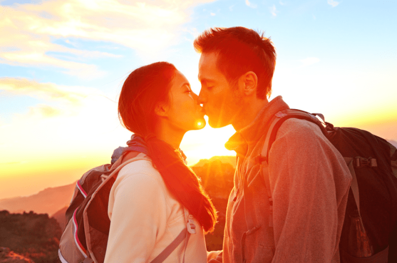 Romantic Lovers Kissing at Sunset While Hiking on a Date
