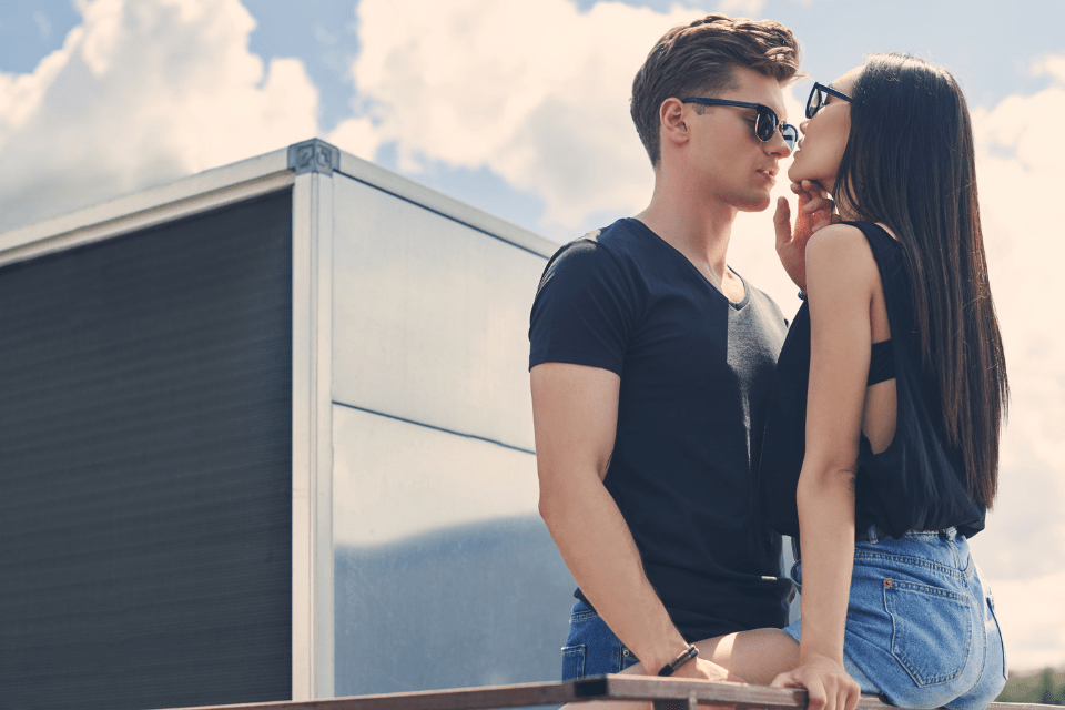 Young Filipina foreigner couple about to kiss on the railings of the roof.