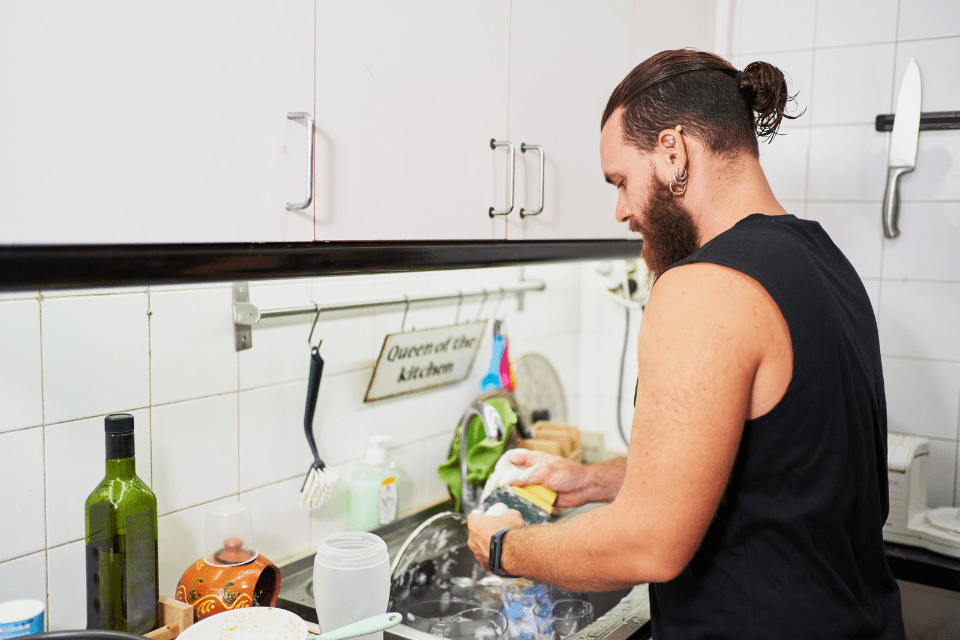 Young Hispanic Man Washing Dishes