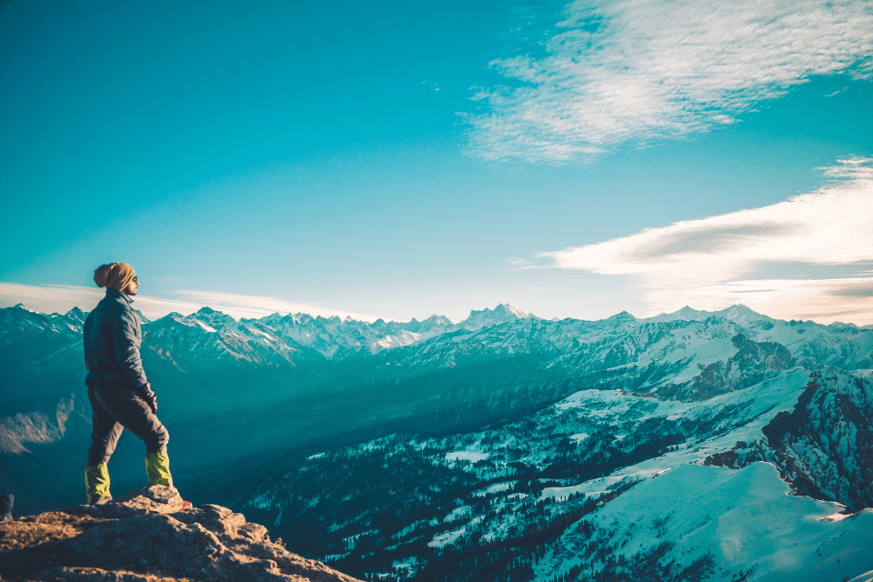 Christian man atop a mountain aiming for personal growth.