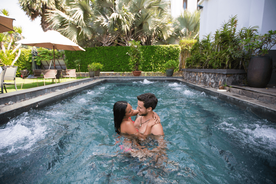 Happy interracial couple hugging in the pool demonstrating trust while navigating financial requests in online relationships.
